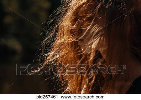 Stock Image - Wind blowing red hair of Caucasian woman. Fotosearch