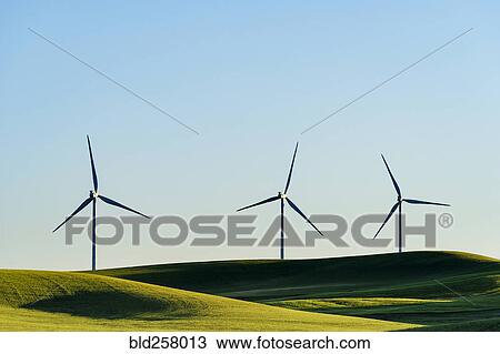 Stock Image - Wind turbines in green rolling landscape. Fotosearch
