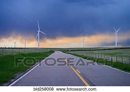 Stock Photo - Wind turbines near road at sunset. Fotosearch