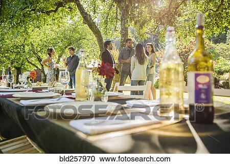 Stock Image - Wine bottles on table at party outdoors. Fotosearch