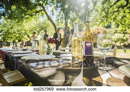 Stock Photo - Wine bottles on table at party outdoors. Fotosearch