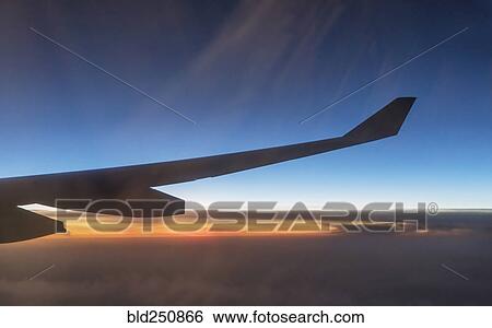 Stock Photograph - Wing of airplane flying in sky. Fotosearch