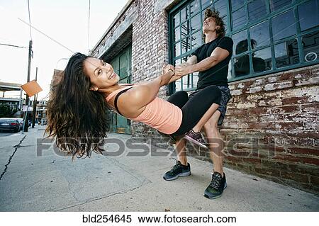 Stock Photography - Woman balancing on thighs of man. Fotosearch
