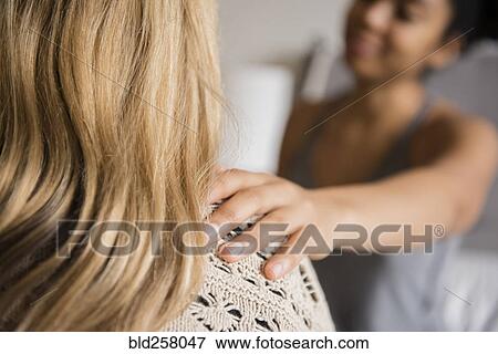 Stock Photo - Woman comforting friend with hand on shoulder. Fotosearch