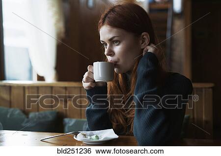 Woman drinking coffee in cafe View Large Photo Image Stock Photograph - Woman drinking coffee in cafe. Fotosearch