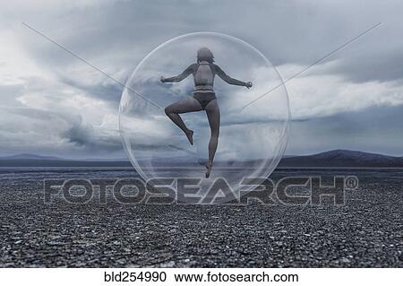 Woman floating in sphere in remote landscape View Large Photo Image Stock Image - Woman floating in sphere in remote landscape. Fotosearch
