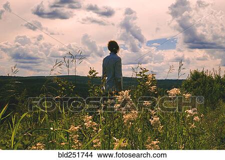 Woman standing in field of wildflowers View Large Photo Image Picture - Woman standing in field of wildflowers. Fotosearch