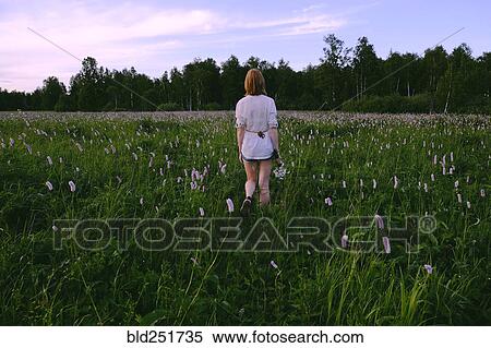 Stock Photography - Woman walking in field. Fotosearch