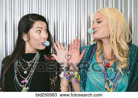 Women chewing gum and showing heart on hands View Large Photo Image Stock Image - Women chewing gum and showing heart on hands. Fotosearch