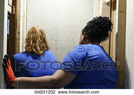 Stock Image - Women examining wall. Fotosearch