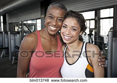 Women hugging in health club View Large Photo Image Stock Photo - Women hugging in health club. Fotosearch