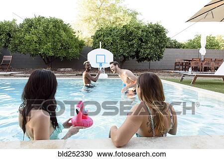 Women watching men playing in swimming pool View Large Photo Image Stock Image - Women watching men playing in swimming pool. Fotosearch