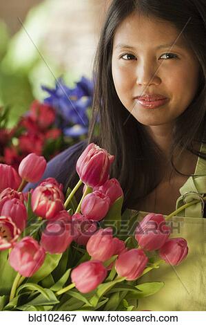 Stock Photo - Asian florist holding tulips. Fotosearch