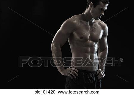 Stock Image - Bare chested Caucasian man with hands on hips. Fotosearch