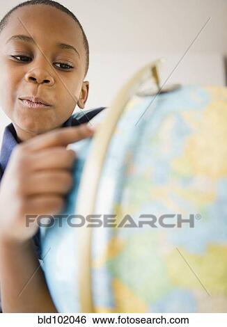 Stock Photograph - Black boy looking at globe. Fotosearch