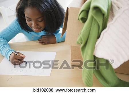 Stock Photo - Black girl donating clothing to charity. Fotosearch