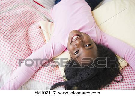 Stock Photo - Black girl laying on bed. Fotosearch
