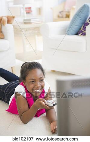 Black girl laying on floor watching television View Large Photo Image Stock Photo - Black girl laying on floor watching television. Fotosearch