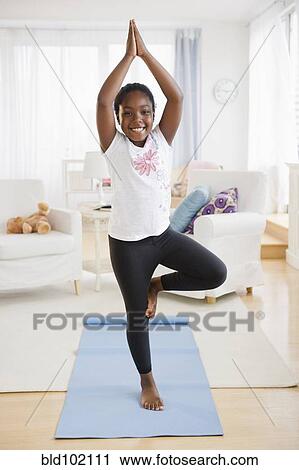 Stock Image - Black girl practicing yoga. Fotosearch