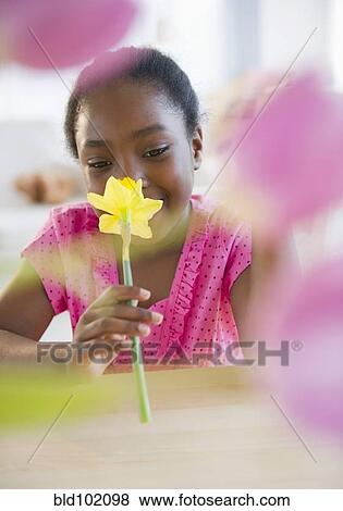 Stock Photo - Black girl smelling flower. Fotosearch