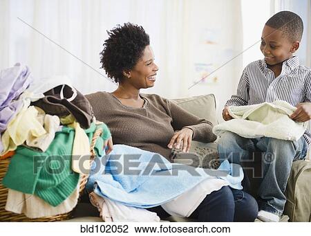 Black mother and son folding laundry View Large Photo Image Stock Image - Black mother and son folding laundry. Fotosearch