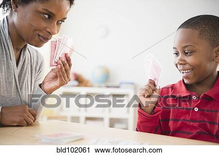 Stock Image - Black mother and son playing cards together. Fotosearch