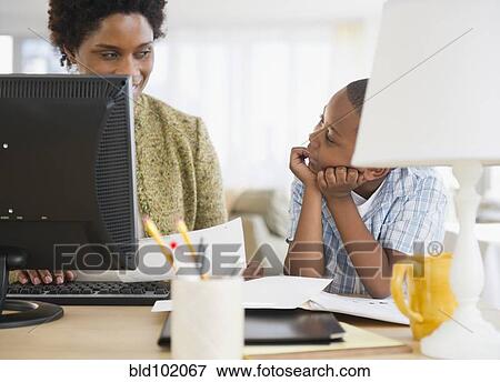 Stock Photo - Black mother and son using laptop together. Fotosearch