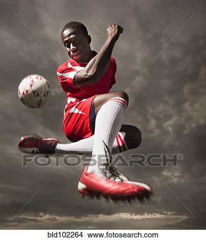 Black soccer player kicking ball View Large Photo Image Picture - Black soccer player kicking ball. Fotosearch