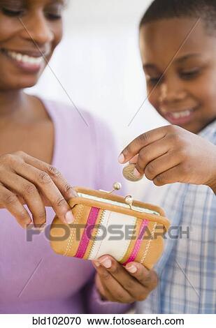 Black son putting coins into mother's purse View Large Photo Image Stock Image - Black son putting coins into mother's purse. Fotosearch