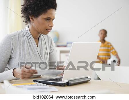 Black woman paying bills online with laptop View Large Photo Image Picture - Black woman paying bills online with laptop. Fotosearch