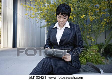 Businesswoman using digital tablet outdoors View Large Photo Image Stock Image - Businesswoman using digital tablet outdoors. Fotosearch