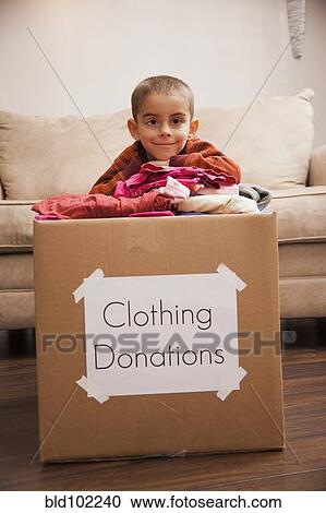 Caucasian boy donating clothing View Large Photo Image Stock Image - Caucasian boy donating clothing. Fotosearch