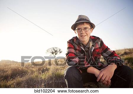 Caucasian boy sitting in remote field View Large Photo Image Picture - Caucasian boy sitting in remote field. Fotosearch