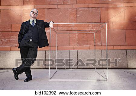 Caucasian businessman leaning on box on sidewalk View Large Photo Image Stock Image - Caucasian businessman leaning on box on sidewalk. Fotosearch