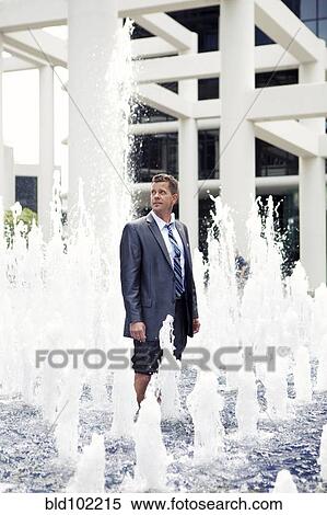 Stock Photography - Caucasian businessman standing in fountain. Fotosearch
