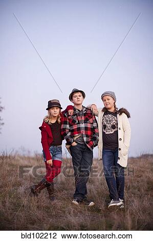 Stock Image - Caucasian children standing in field. Fotosearch