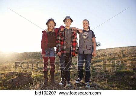 Stock Photo - Caucasian children standing in field. Fotosearch