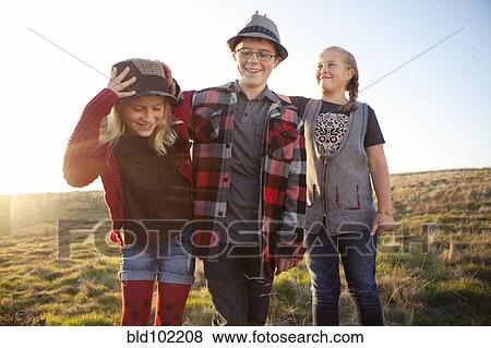 Stock Photo - Caucasian children standing in field. Fotosearch
