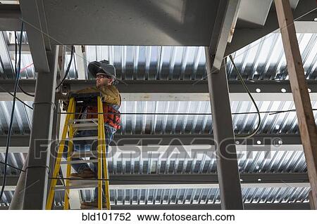 Caucasian construction worker standing on ladder View Large Photo Image Stock Image - Caucasian construction worker standing on ladder. Fotosearch