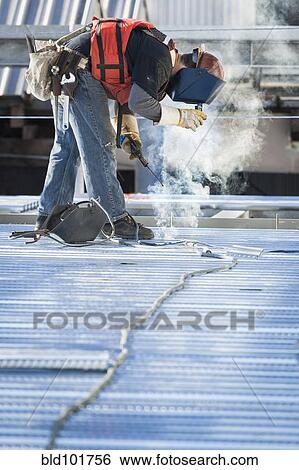 Stock Photograph - Caucasian construction worker welding floor. Fotosearch