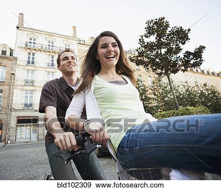 Stock Photo - Caucasian couple riding bicycle together. Fotosearch