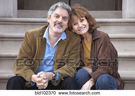 Stock Image - Caucasian couple sitting on front stoop. Fotosearch