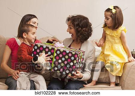 Caucasian family giving grandmother gift View Large Photo Image Stock Photo - Caucasian family giving grandmother gift. Fotosearch