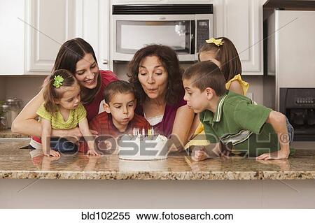 Caucasian family in kitchen blowing out birthday cake View Large Photo Image Stock Photography - Caucasian family in kitchen blowing out birthday cake. Fotosearch