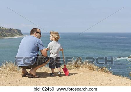 Stock Photo - Caucasian father and son on beach. Fotosearch