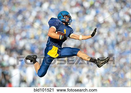 Stock Image - Caucasian football player running with football. Fotosearch