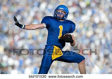Stock Image - Caucasian football player running with football. Fotosearch