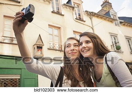 Stock Image - Caucasian friends taking self-portrait. Fotosearch