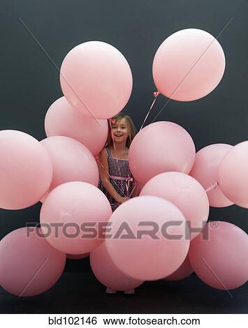 Stock Photograph - Caucasian girl holding large balloons. Fotosearch
