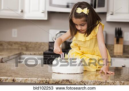 Caucasian girl putting candles on birthday cake View Large Photo Image Stock Image - Caucasian girl putting candles on birthday cake. Fotosearch